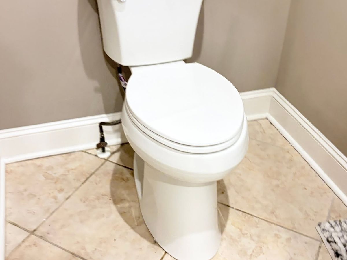 New white two-piece toilet installed on a tile floor