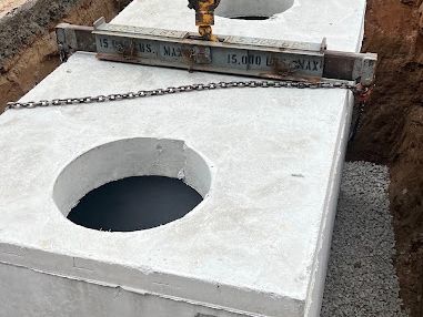 Concrete tank being lowered by chain