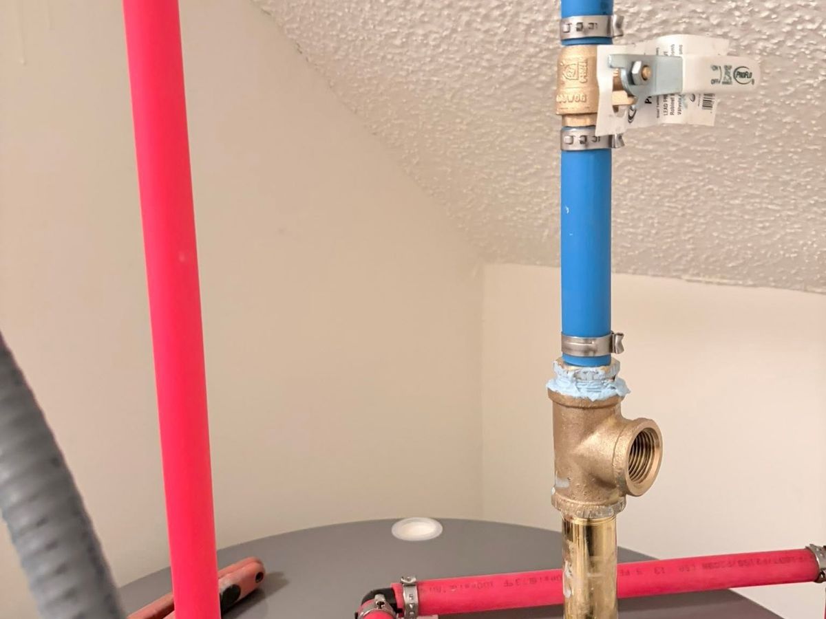 Closeup of red and blue PEX lines, a brass ball valve
