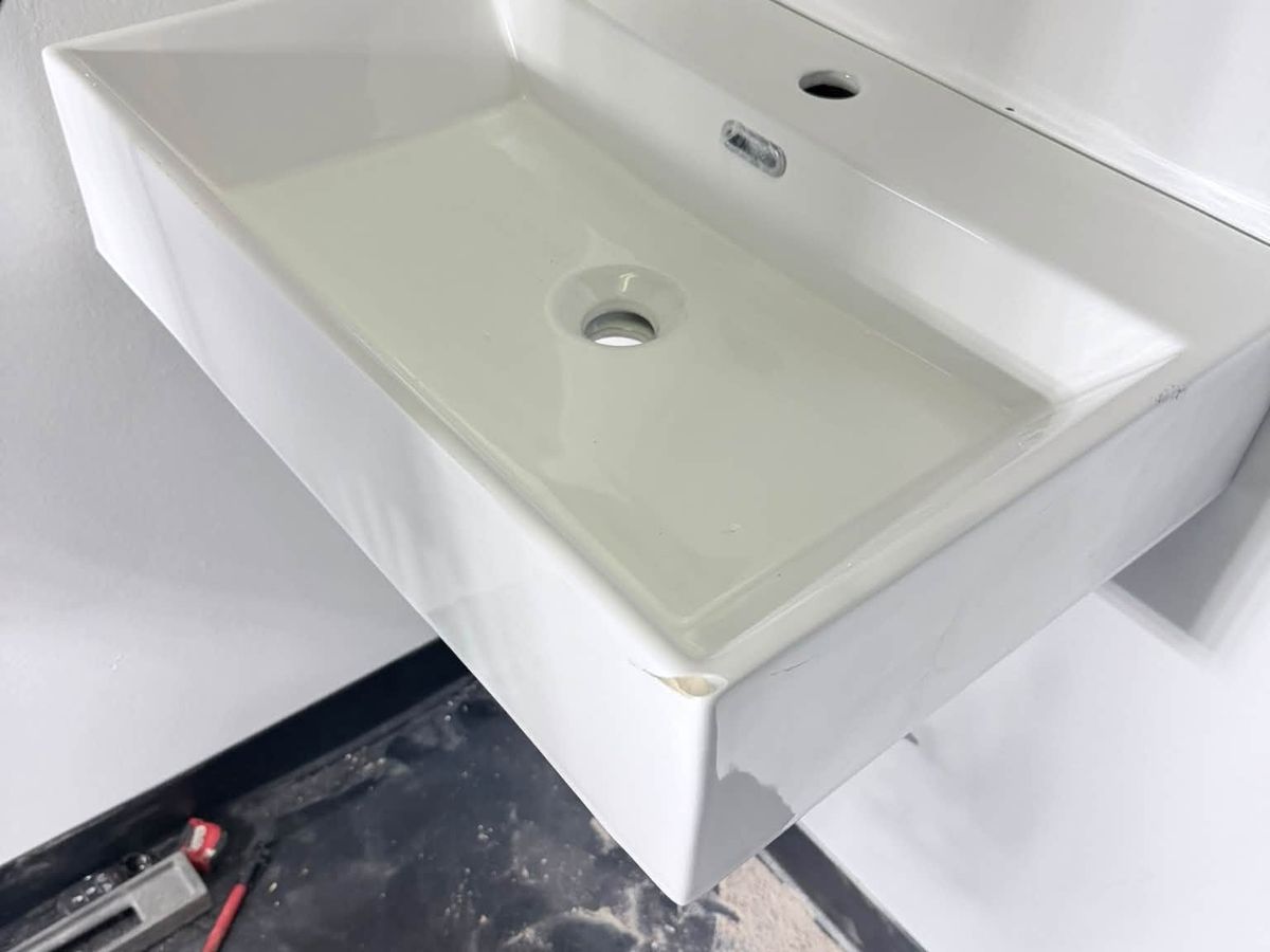 White wall-hung rectangular sink mounted in a room