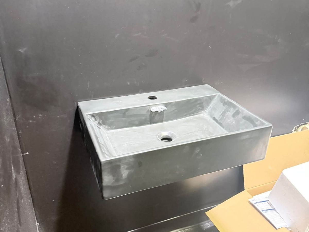 Gray wall-mounted rectangular sink with no faucet