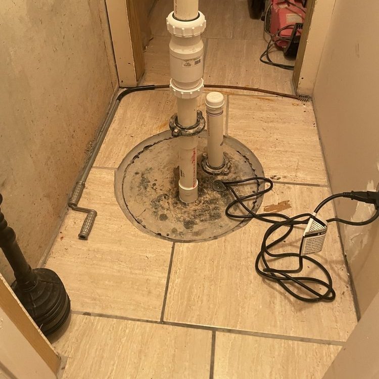 Sump pit with a PVC pipe in a tiled closet