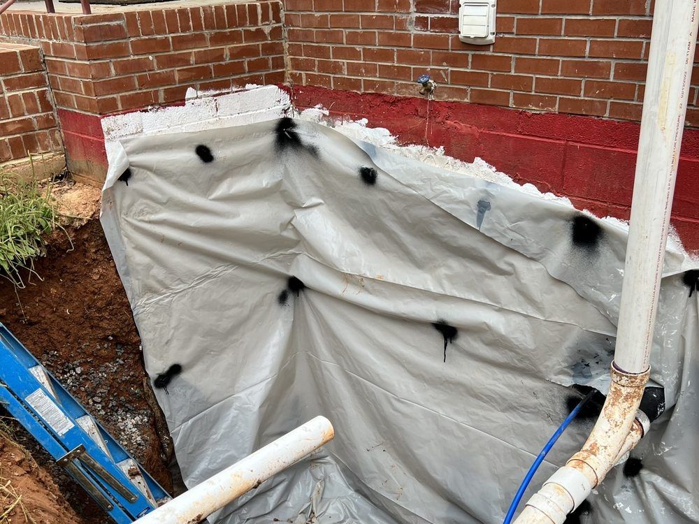 Excavation along a red-painted block wall