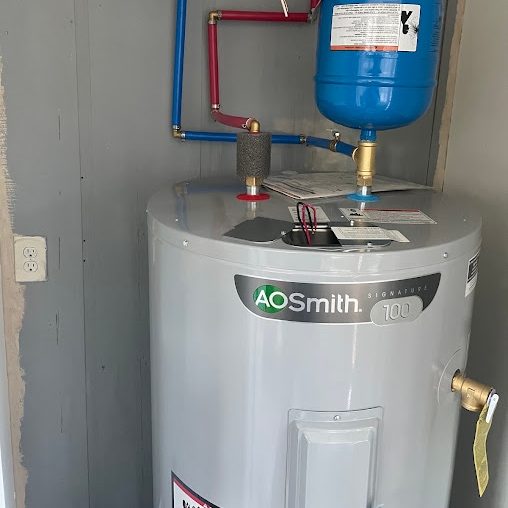 New electric tank water heater with blue and red PEX, a blue expansion tank, and flex conduit in a gray closet