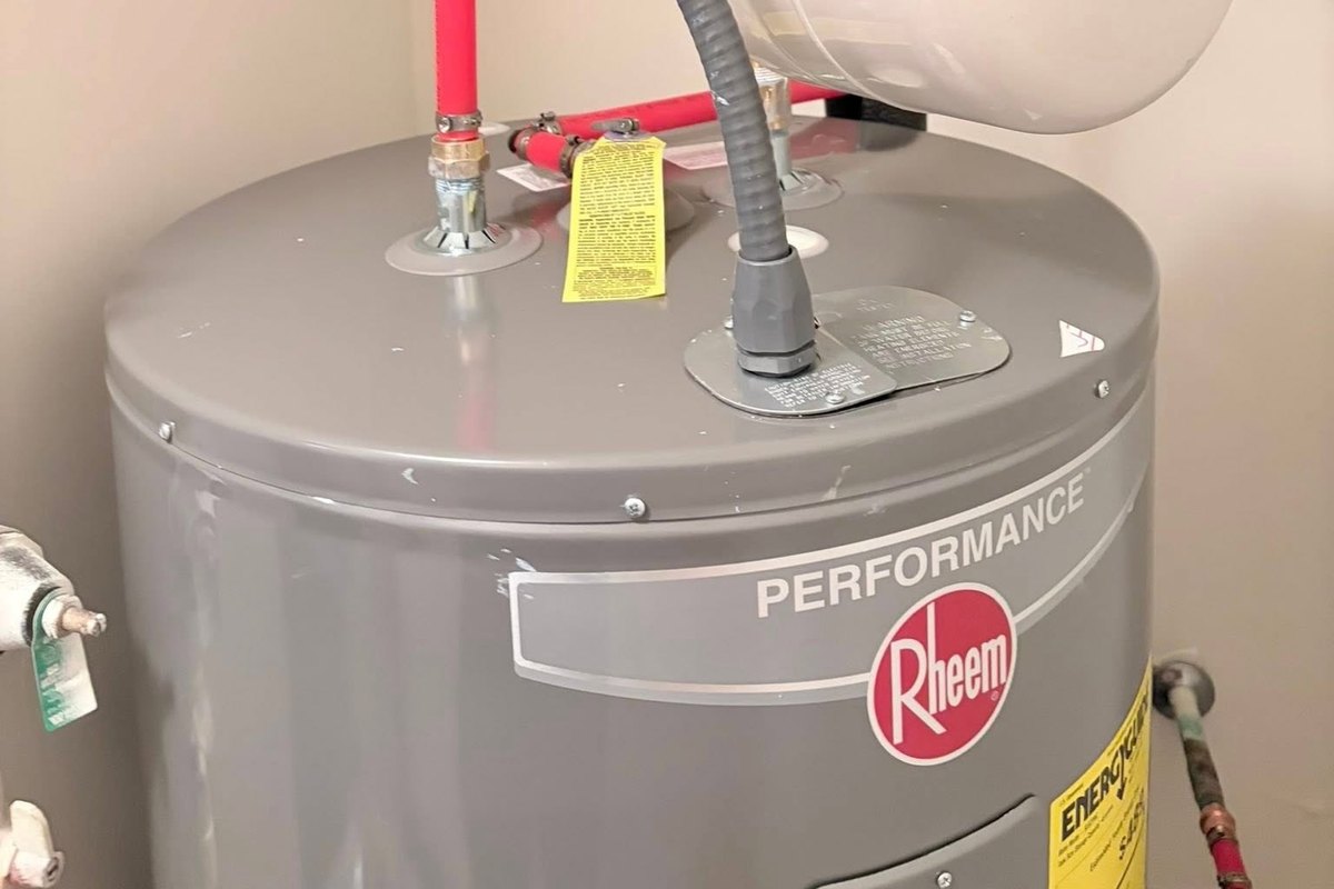 New electric tank water heater with red PEX and gray conduit on top